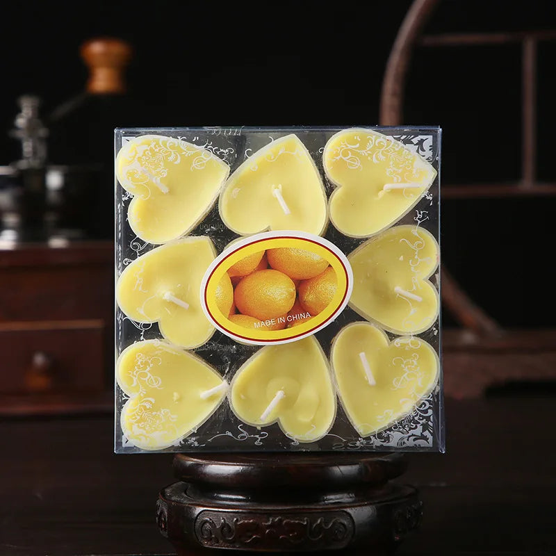 Un ensemble de bougies parfumées en forme de cœur et jaunes, emballées dans une boîte transparente.