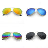A set of classic pilot sunglasses shown in three colors: orange, blue, and mirrored green/rainbow, with a black pair also vis