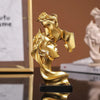 Statue en résine dorée de deux profils féminins s'étreignant, sur une base noire.