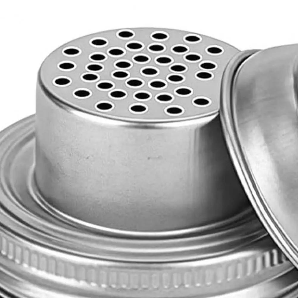 Stainless steel mason jar shaker lid with a perforated top and a matching base.