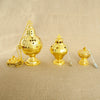 A set of gold-plated Orthodox censers with bells and spoons displayed on a beige fabric background.