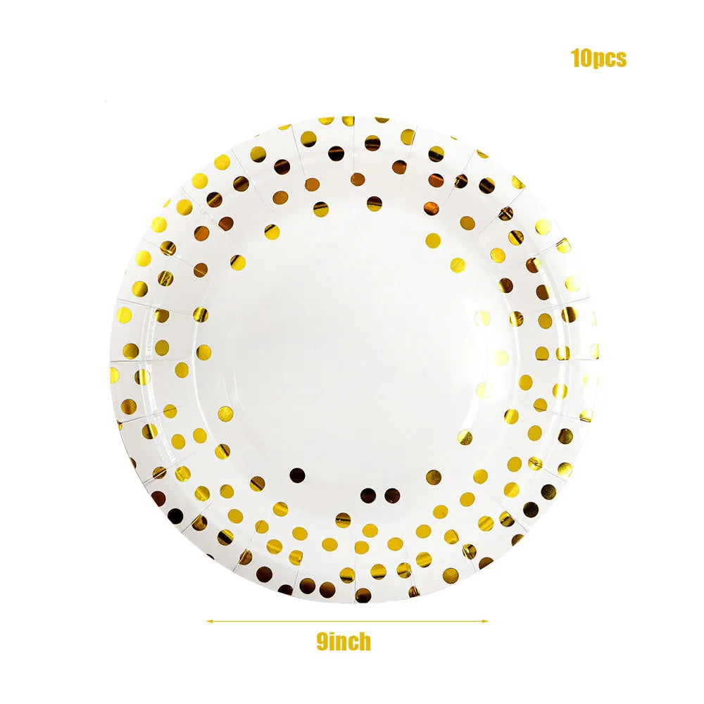A plate of white disposable party tableware decorated with gold polka dots.