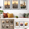 A display of various framed photographs in black frames on a wooden surface.