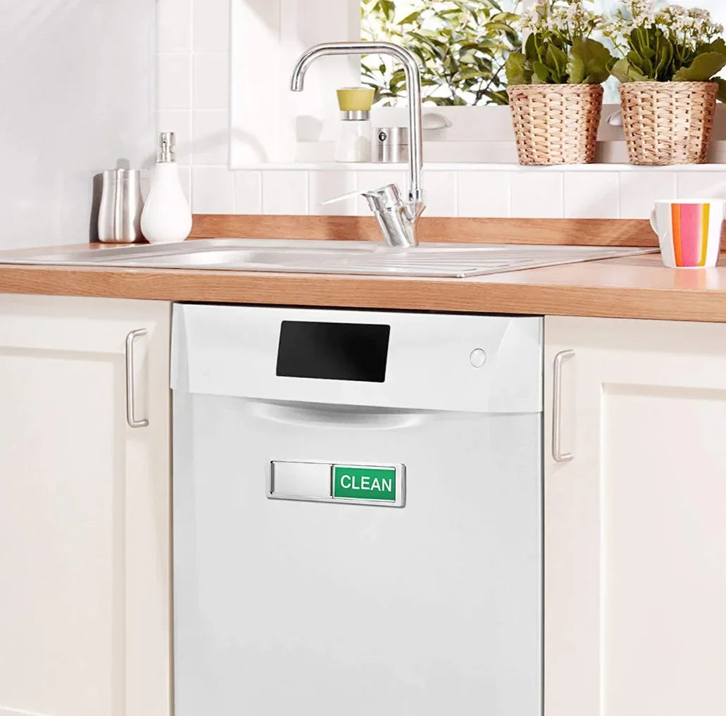 A white dishwasher with a green CLEAN magnet sign installed on the front panel.