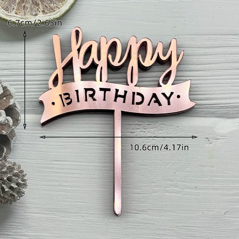 A pink acrylic birthday cake topper featuring the words Happy Birthday on a banner shape.