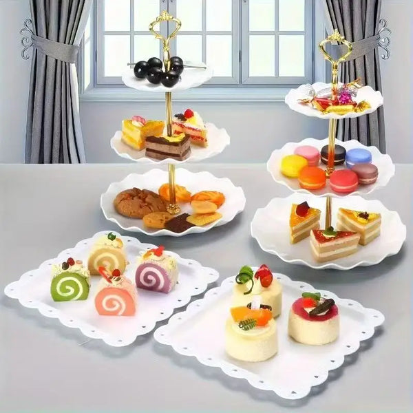 Un juego de bandejas y soportes decorativos blancos para exhibir postres y pasteles pequeños.