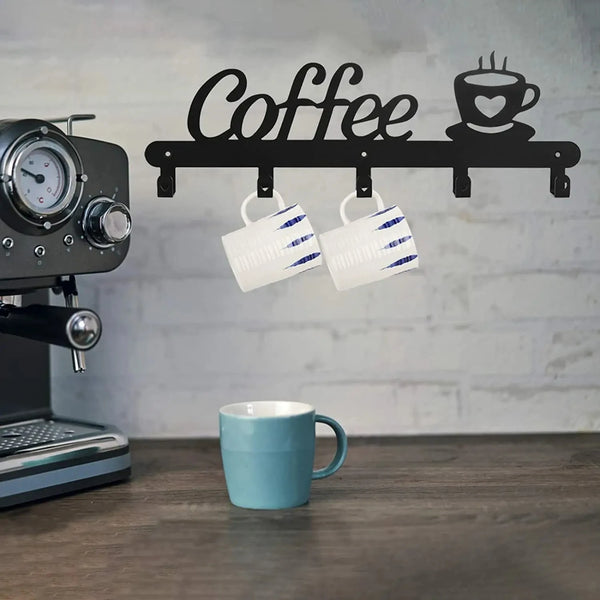 A black wall-mounted coffee mug rack with heart hooks is displayed against a light gray brick background.