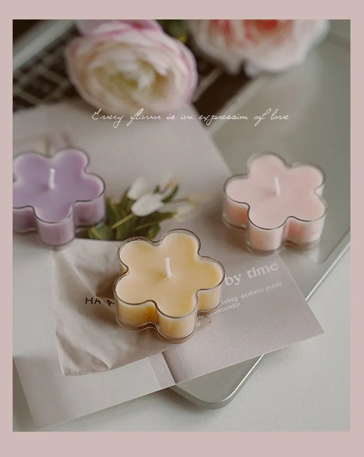 A collection of handmade soy wax flower tea light candles in various pastel colors, set against a soft background.