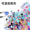 A pile of colorful resin rhinestones in various shades including blue, pink, green, and gold.