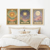 A set of three framed celestial wall art prints featuring the sun, a star, and the moon on a muted background.