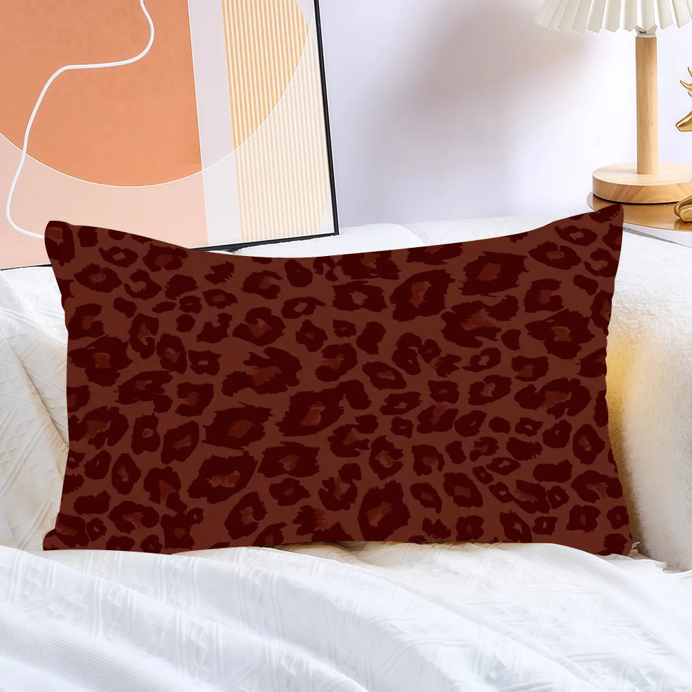 A brown leopard print decorative pillow cover resting on white bedding.