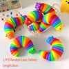 One piece of a colorful, flexible, striped fidget slug toy with bright rainbow colors.