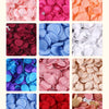 A collection of silk rose petals in various shades including pink, magenta, red, blue, and white.