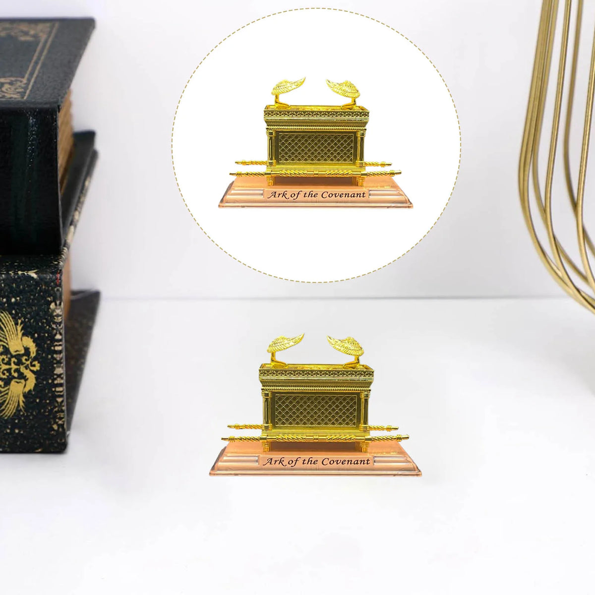 A golden metal statue of the Ark of the Covenant resting on a wooden base.