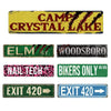 A collection of vintage metal wall signs featuring text like Camp Crystal Lake, Elm St., and Exit 420.