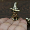 A vintage brass cat statue with a wide-brimmed hat is held in a person's hand.
