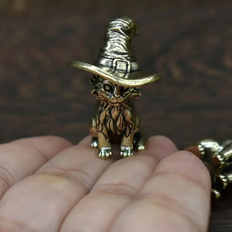 Handgefertigte Kupferkatze-Eulenstatue mit Hut auf menschlicher Hand.