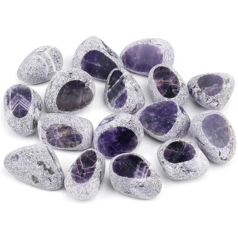 A collection of tumbled natural crystals including clear quartz, rose quartz, and amethyst in various shades of purple and gr