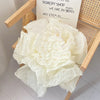 A pile of white soft tissue paper sheets for gift wrapping and DIY crafts is displayed next to a sign.