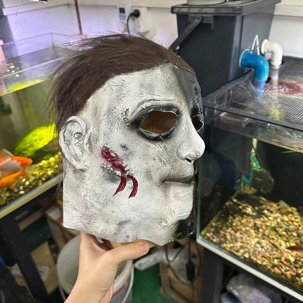 A realistic horror mask resembling Michael Myers, sculpted in gray and black tones.