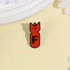 An enamel pin featuring an orange shark head design with the letter F on a light yellow background.