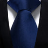 A dark blue silk necktie with a diagonal stripe pattern worn against a black suit jacket.