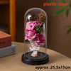 A glass dome display featuring a pink rose and dried floral elements on a black base.