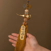 A brass gourd and five emperor coins hanging ornament on a gold thread.
