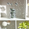 A stack of reflective mirror tiles shaped like a disco ball vase with three small spherical mirrors on sticks.