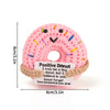 Handmade crochet pink donut doll with colorful sprinkles and an inspirational slogan tag