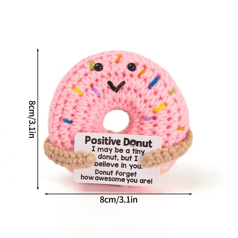 Handmade crochet pink donut doll with colorful sprinkles and an inspirational slogan tag