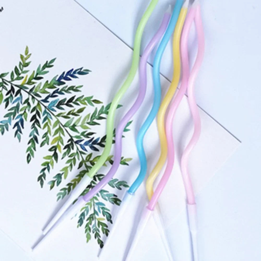 A collection of curved metallic birthday cake candles in pastel colors, including green, blue, yellow, and pink.