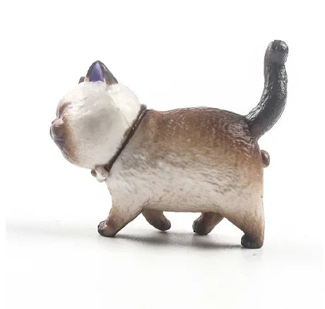 A small, light gray and white 3D cartoon cat figurine used as a refrigerator magnet.