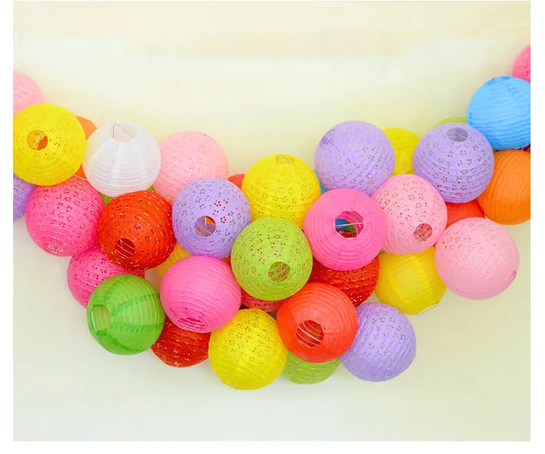 A colorful arrangement of round paper lanterns in various shades including yellow, pink, orange, purple, and green.