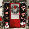 Festive Christmas door banner featuring holiday greetings like HO HO and a wreath on a red door decorated with greenery and f