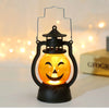 An orange glowing LED pumpkin lantern with a smiling face is displayed on a dark base.