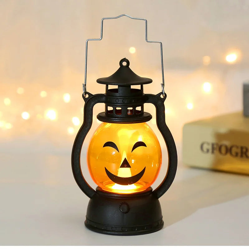 An orange glowing LED pumpkin lantern with a smiling face is displayed on a dark base.