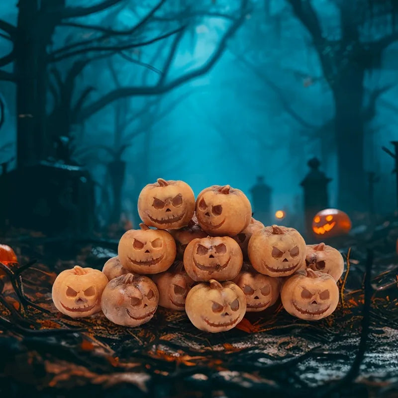 A pile of small, carved resin pumpkins with spooky faces resting on dark, textured ground in a foggy forest setting.