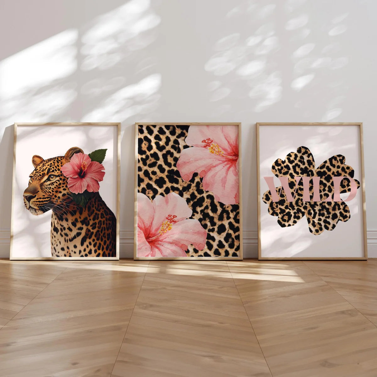 Three framed canvas prints featuring leopard print, pink hibiscus flowers, and the word WILD.