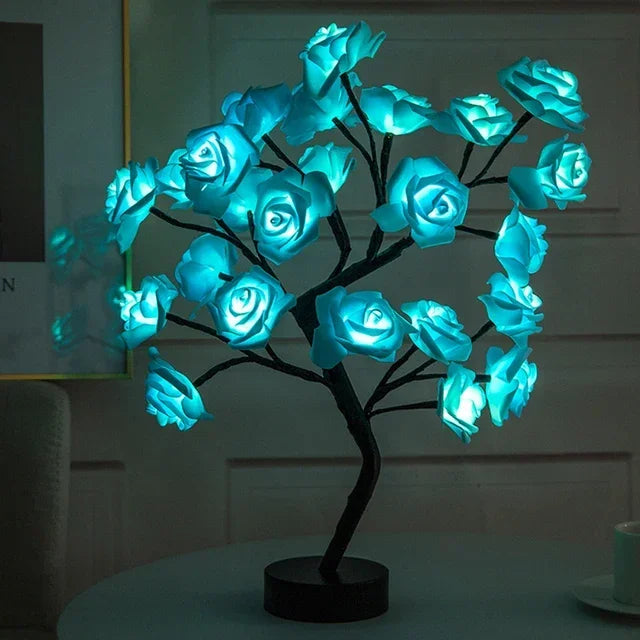 Sculpture d'arbre sombre avec des roses bleues lumineuses, servant de lampe de table LED.
