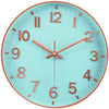 A light blue minimalist wall clock face with rose gold numbers and hands displaying the time.