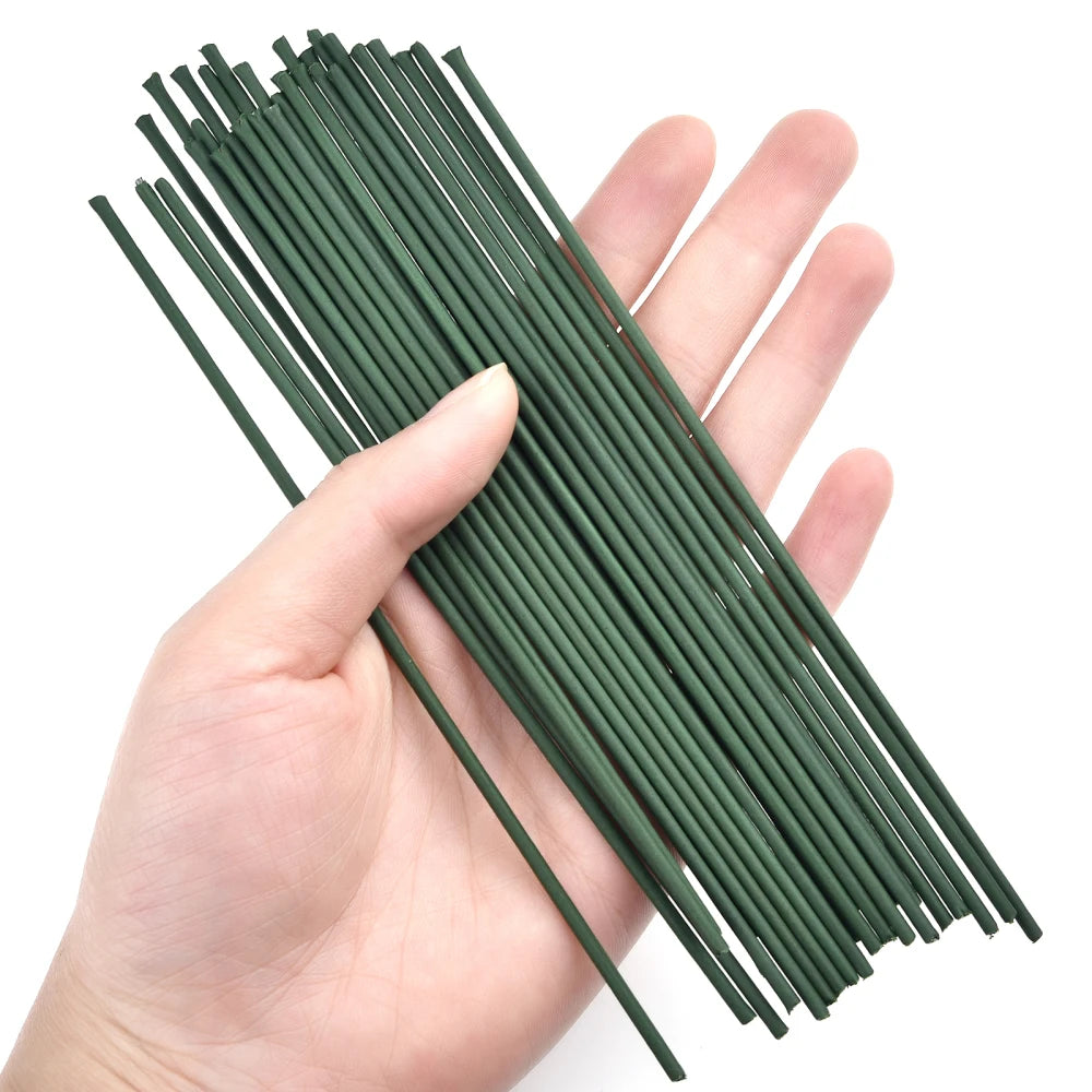 A hand holds a bundle of thin, green artificial flower stems for DIY floral decor.