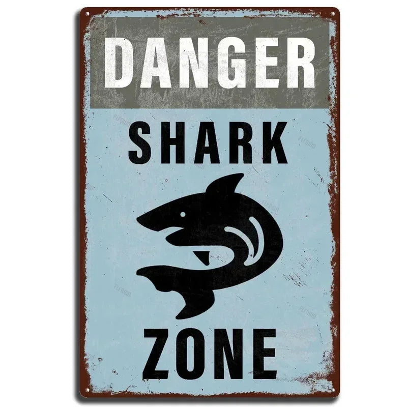 A vintage distressed tin sign with the text DANGER SHARK ZONE on a blue background.