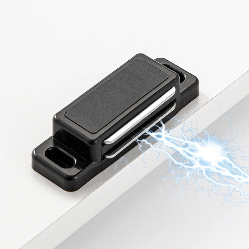 A black magnetic cabinet door latch closure with a silver release mechanism, demonstrating an electrical spark.