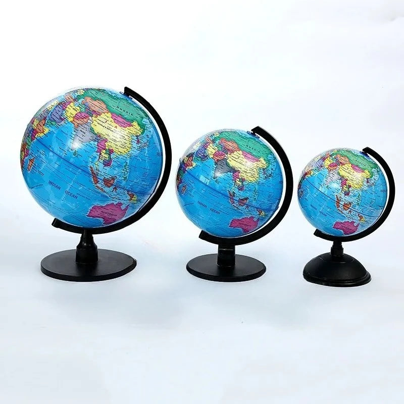 Three desktop educational globes showing the Earth's surface from different angles.