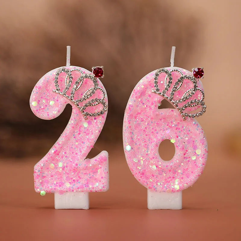 A set of two pink glitter birthday candles shaped like the numbers 2 and 6 with silver crown accents.