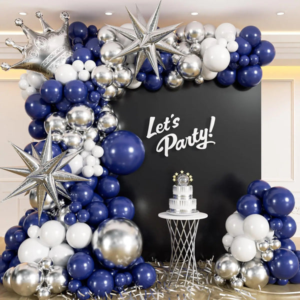 A balloon garland arch kit featuring navy blue and silver balloons decorating a backdrop with a party sign and cake.