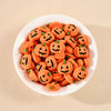 A white bowl filled with 20 orange resin pumpkin charms for fall decor.