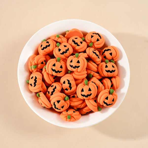A white bowl filled with 20 orange resin pumpkin charms for fall decor.