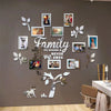 A wall collage featuring various framed photos and decorative leaves arranged in the shape of a family tree.